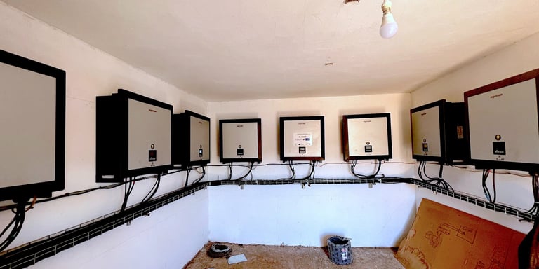 a room with multiple solar inverters on the wall