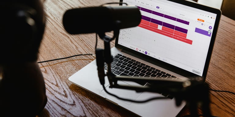 Microphone on a table and a laptop with a radio automation system open