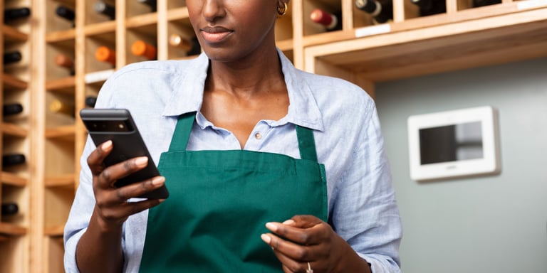 a woman in a green apron and a wine bottle