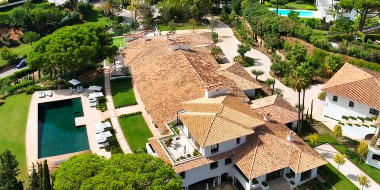 Aerial view of grand estate with pool, guest house and landscaped grounds