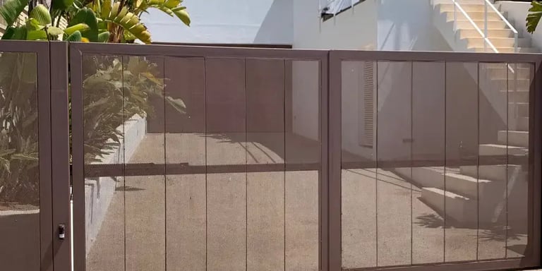 Puerta abatible automática elegante para viviendas en Ibiza