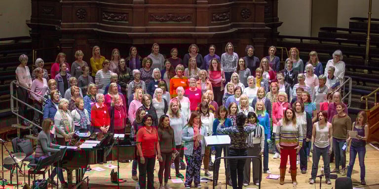 Female choir singing with a pianist and conductor