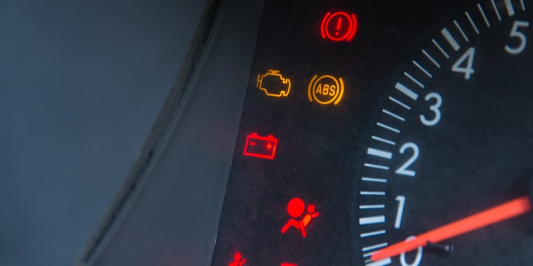 a car dashboard with warning lights ON