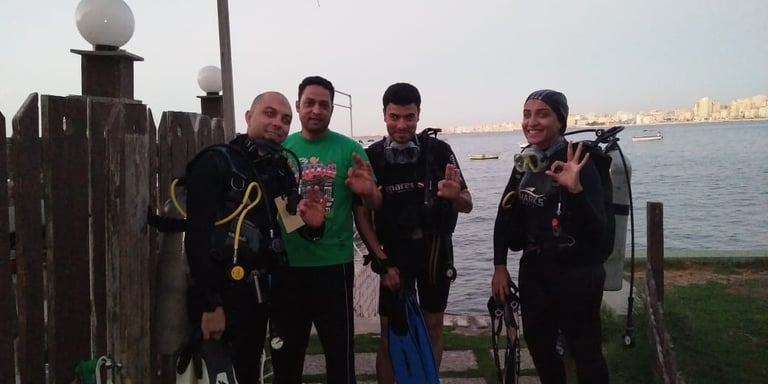 a group of Divers standing around Captain Essam