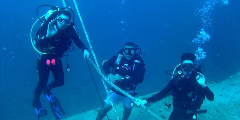 a group of divers in scuba gear on a shipwrwrack