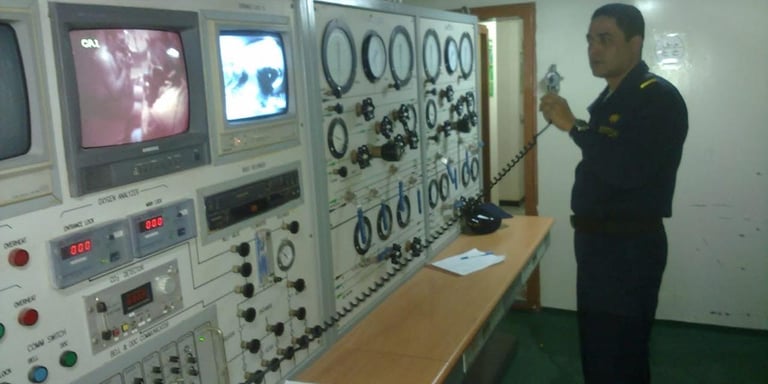 Captain Essam in uniform standing in front of a control panel