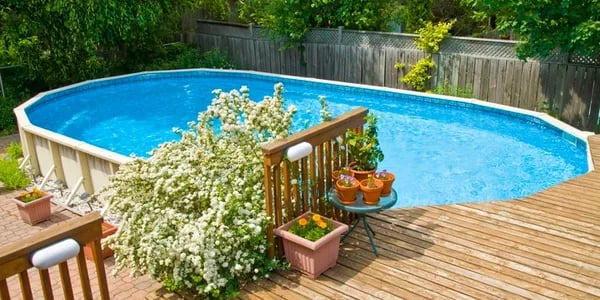 an above ground pool with a custom built deck with stairs