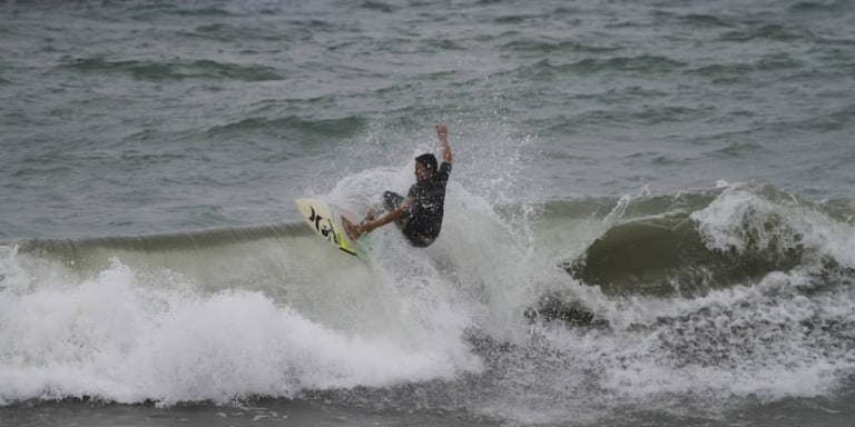 A surfer riding a crappy wave in windy day