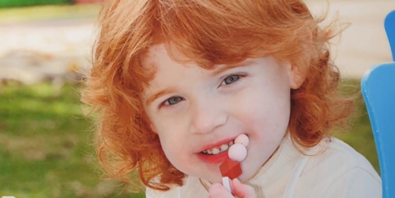 a young girl with red hair and a white shirt