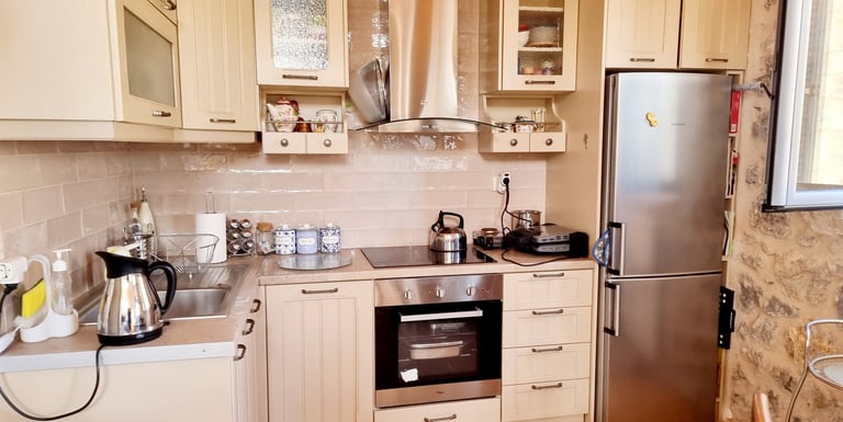 a kitchen with a refrigerator, stove, and a table