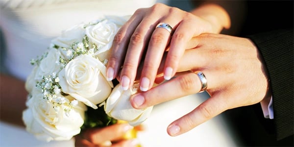 a bride and groom holding hands with their hands together