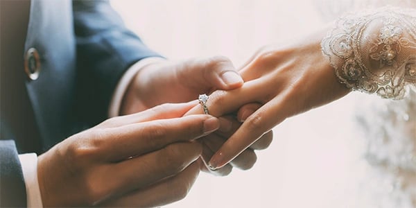 a man and woman holding hands and wedding rings
