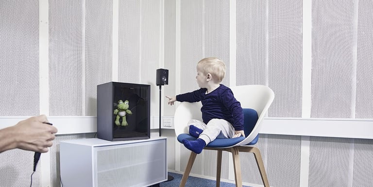 Criança fazendo exame de audiometria com reforço visual
