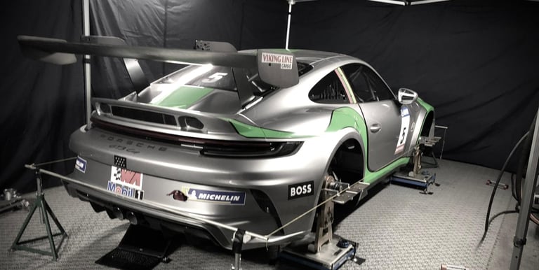 an Enlab Porsche car is parked in a garage with a car in the background