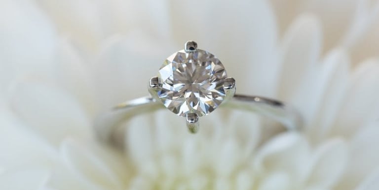 a Lab-Grown Diamonds CVD cut diamond ring with a diamond ring on top of a white flower