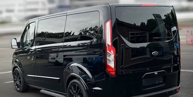 a black van parked in an airport parking lot