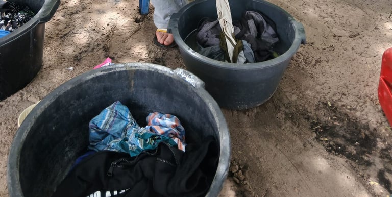 Photo d'un jeune accompagné par Bourokk et Kadiamor qui s'occupe de laver son linge à la main