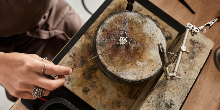 Joyero utilizando un soplete de gas para soldar un anillo de plata