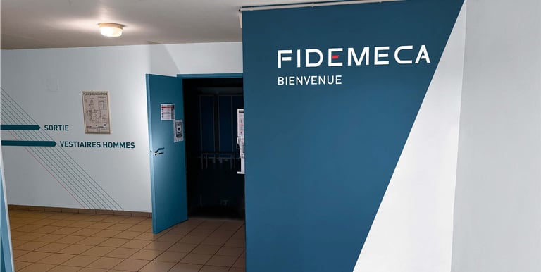 un couloir avec un panneau bleu et blanc indiquant Fidemeca