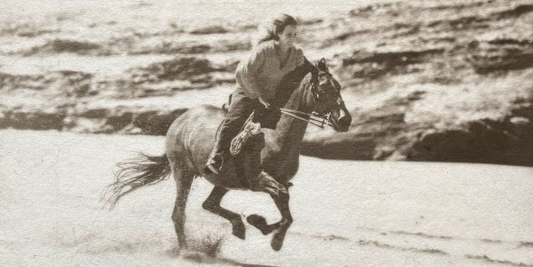 Black and white photograph in silver and Platinum of a woman riding a horse on a beach