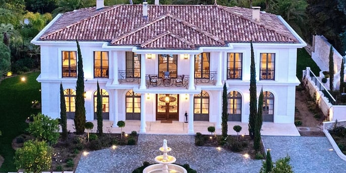 a large mansion with a fountain in the foreground