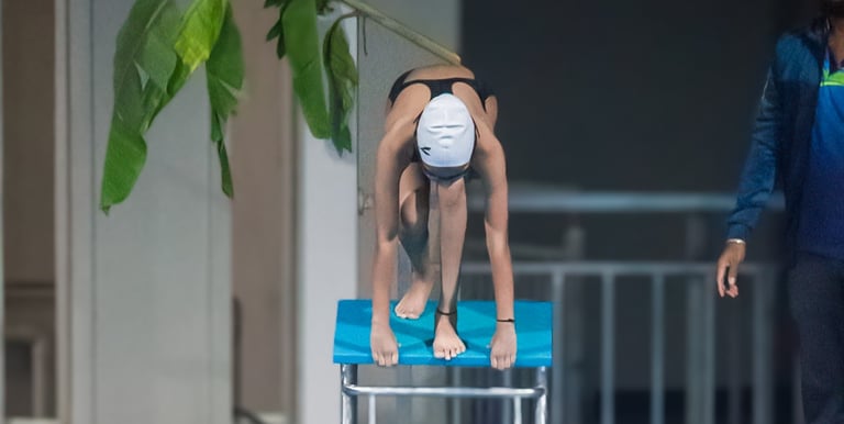 “Instructor assisting a swimmer preparing to dive into the pool for rehabilitation exercises.”