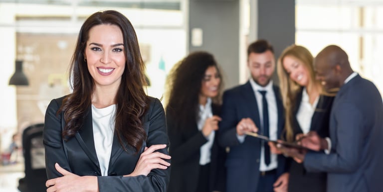 mujer en un traje parada al frente de un grupo de trabajo
