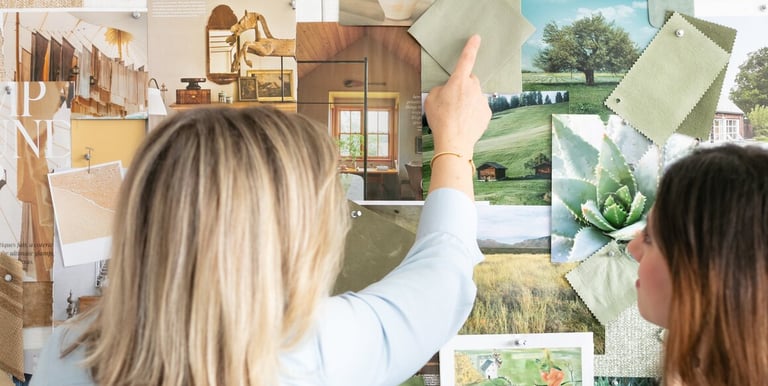 Interior designers review a green mood board with fabric swatches and nature photography for home decor inspiration.