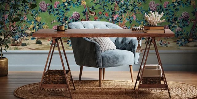 Vintage style floral chinoiserie wallpaper in a home office with a blue armchair and wooden desk.