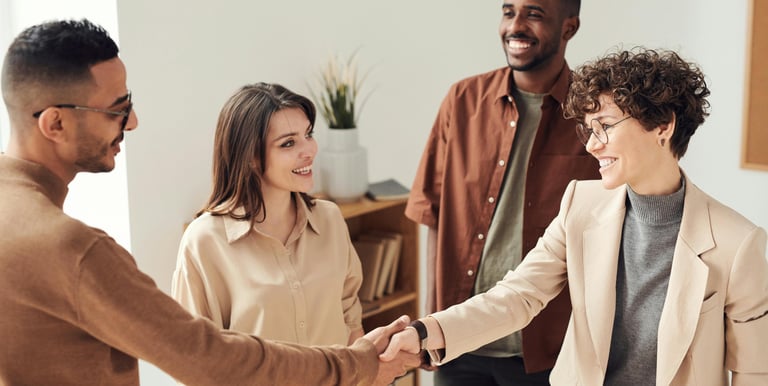 a group of people shaking hands with a woman in a suit