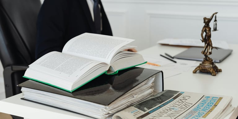 a man in a suit is sitting at a desk with a book