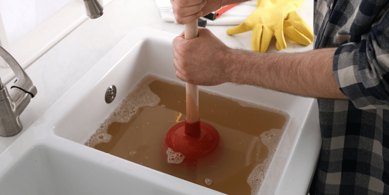 Plumber Unclogging and cleaning drain 
