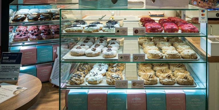 Donutería en Bratislava mostrando vitrina con donuts y pasteles variados, repostería artesanal