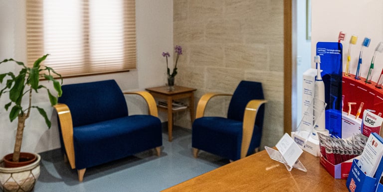 a room with a desk and chairs and a plant