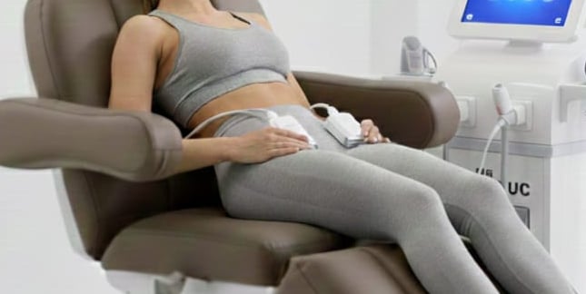 a pregnant woman sitting in a chair with a laptop