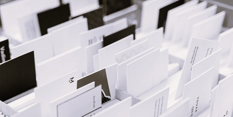 Photo en noir et blanc de plusieurs cartes de visite et supports triés