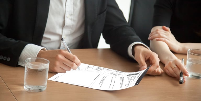 Pessoas assinando a ATPV para transferência de veículo.