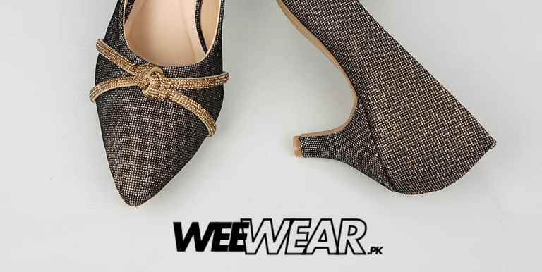 a pair of shoes with a gold buckle on the heel