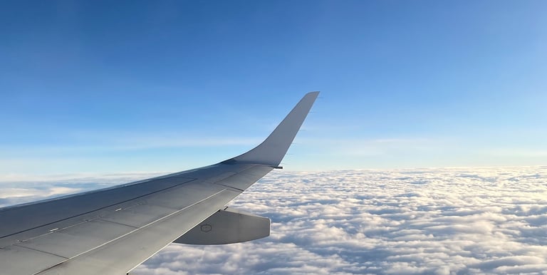 a view of a wing of a plane above the clouds