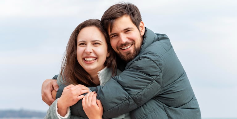a man and woman hugging each other on a beach
