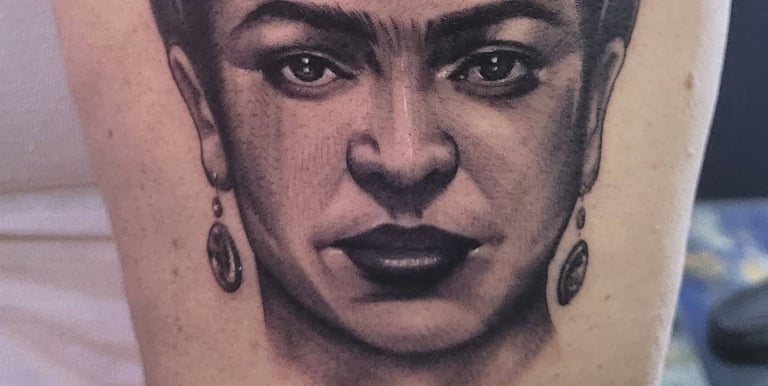 Realistic leg tattoo of Freida Khalo's face by contemporary Puerto Rican artist Miguel Pena