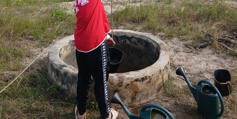 Photo d'un jeune accompagné par Bourokk et Kadiamor qui cherche l'eau dans le puit