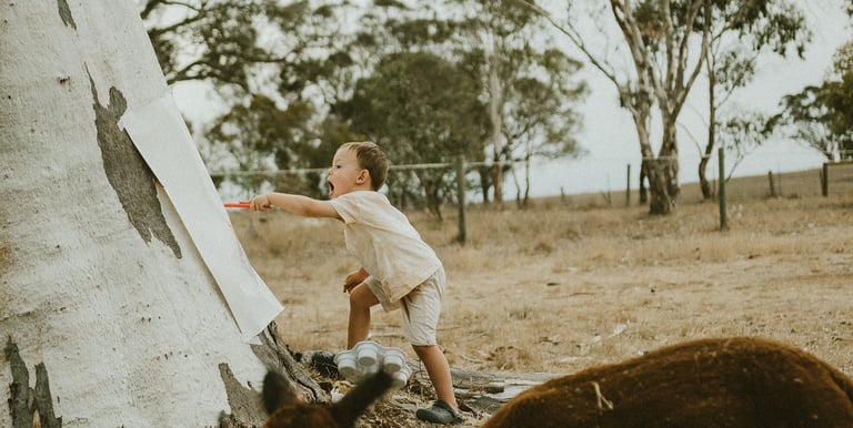 toddler painting in nature as part of a candid family session in Adelaide Hills