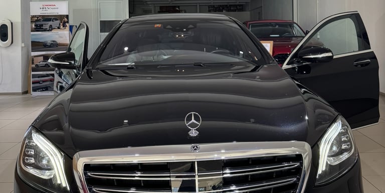 Black Mercedes S-Class with open doors in the hall of a carselling Store