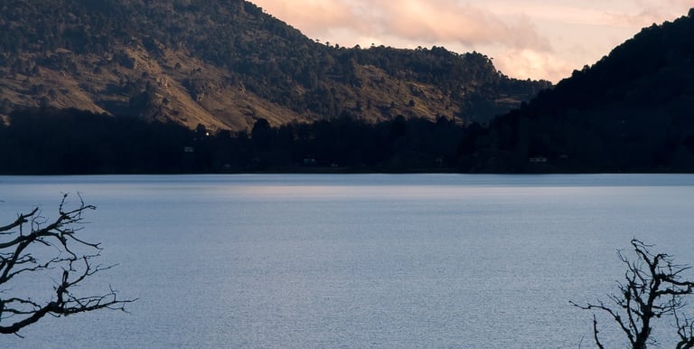 Paisaje sereno de laguna altoandina en Lonquimay (Icalma o Galletué) con montañas de fondo al atarde