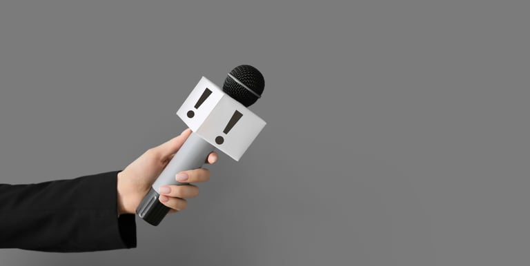 Main en veston noir tenant un microphone de journaliste — prise de parole publique et relations médias professionnelles