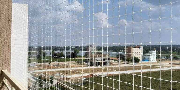 Close-up of a securely installed balcony safety net on a high-rise apartment.