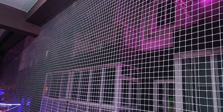 Close-up of a sturdy balcony pigeon net securely installed on a BTM Layout apartment.