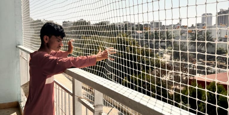 Close-up of a securely installed balcony safety net with a child playing safely behind it.