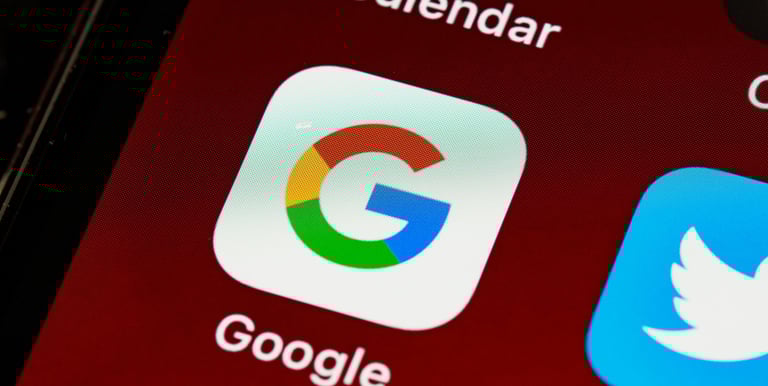 Close-up of the Google search app icon on a smartphone screen next to Twitter and Calendar.